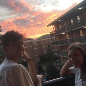 Photo of students enjoying a sunset view from a balcony on south campus