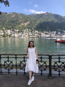 Celeste wearing a white dress and standing in front of is me in front of a lake in Como, Italy.